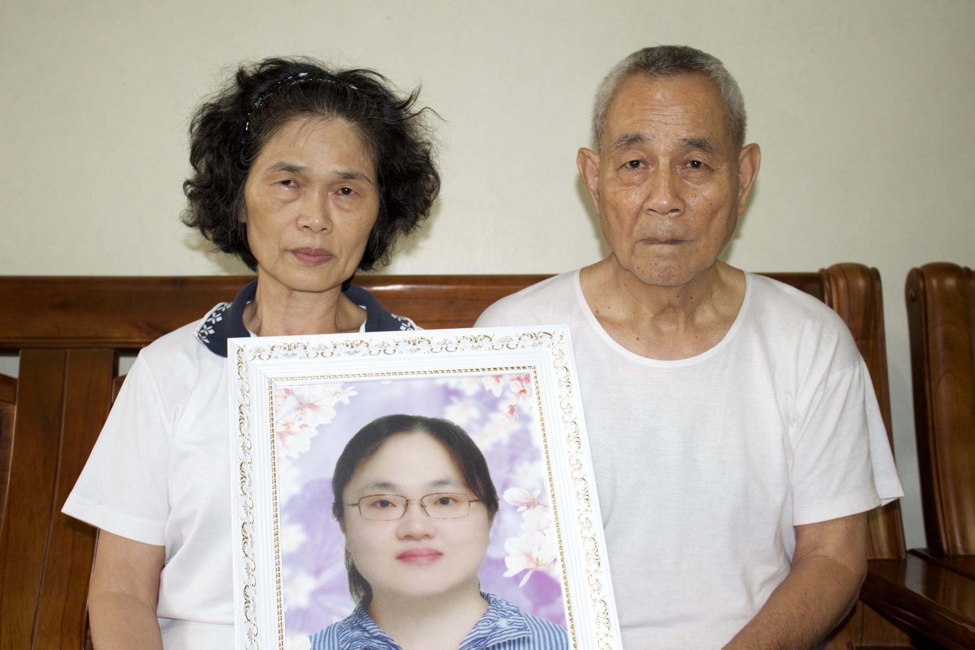 羅玉芬父母手捧女兒遺照。(攝影/汪少凡)