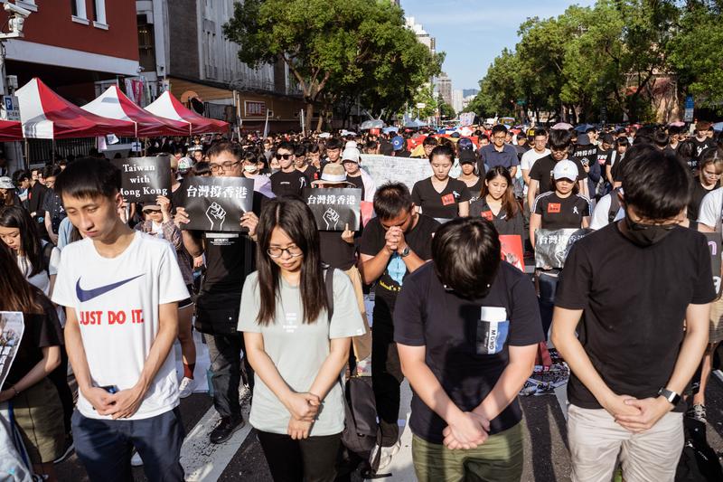 參與台灣「撐香港，反送中」集會的群眾，低頭為6月15日在香港金鐘墜樓的梁姓男子默哀。（攝影／許𦱀倩）