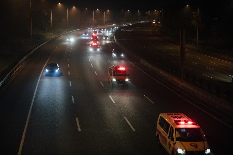 轉送返抵台灣的鑽石公主號乘客至各醫院的救護車在國道公路上疾馳。（攝影／余志偉）