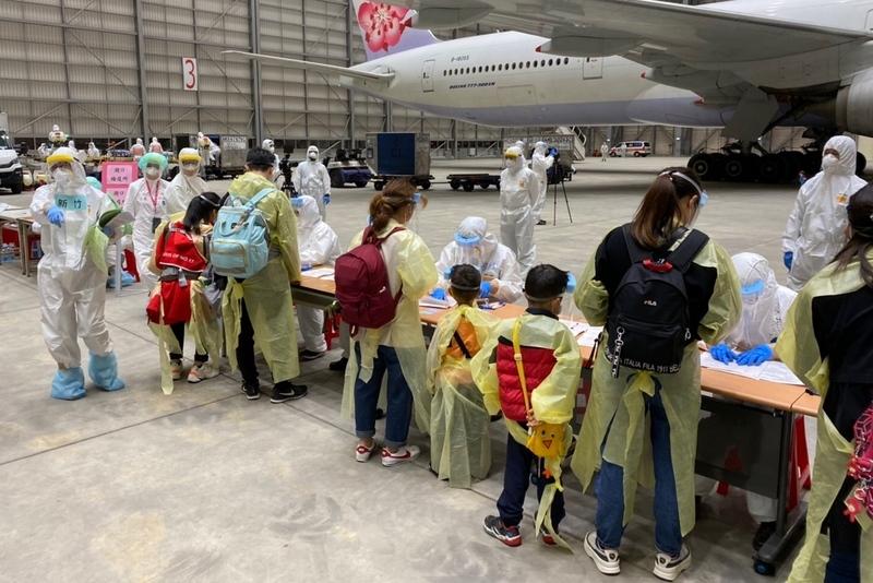 第2批湖北類包機乘客20日晚間抵台，旅客在班機落地後在機棚內排隊並進行消毒及檢疫工作。（照片提供／中央社）