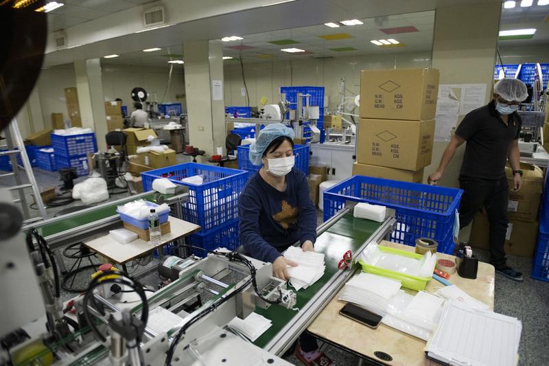 20多人的小工廠擁有穩定高產能，產線上的員工忙著檢查口罩成品，完全沒有喘息空間。（攝影／楊子磊）