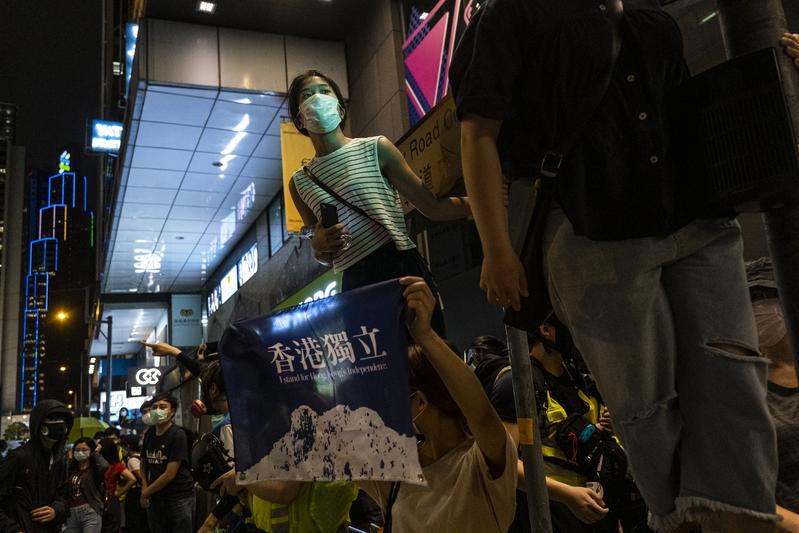 近千位帶著口罩的市民高舉開啟手電筒模式的手機，喊著「五大訴求，缺一不可」、「光復香港，時代革命」等口號，也有人舉著「香港獨立」的旗子在遊行人群之中，喊出「香港獨立，唯一出路」。（攝影／陳朗熹）