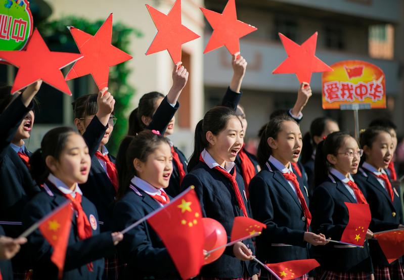 2019年在內蒙古自治區首府呼和浩特市的小學生，於開學儀式上手持旗幟標語高唱愛國歌曲。（攝影／REUTERS／達志影像）