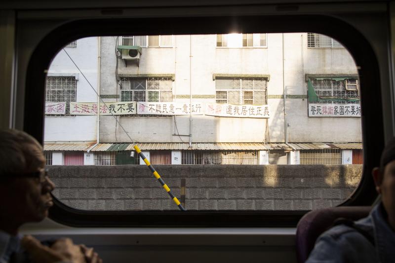 2019年4月，台鐵車輛行經市區時從車窗可見到懸掛於房屋外牆的反迫遷標語。（攝影／楊子磊）