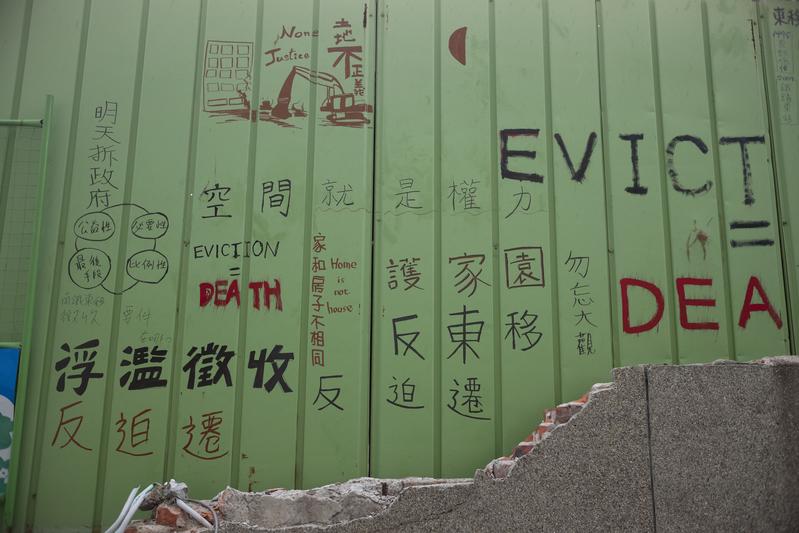 南鐵反迫遷戶巷口的鐵皮圍籬上，有聲援者留下的文字。（攝影／楊子磊）