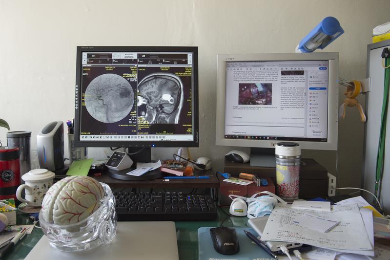 林俊甫的辦公室裡放著兩台電腦，他常常在手術前反覆研究病人的X光片。（攝影／林彥廷）