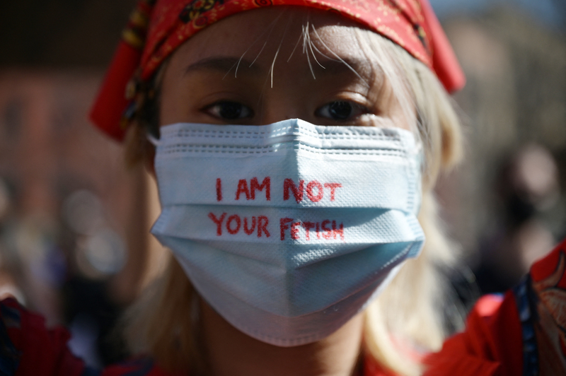 參與紐約哥倫布公園「反仇恨遊行」的亞裔女性，口罩上寫著反對被偏見物化的標語。（攝影／AFP／Ed JONES ）