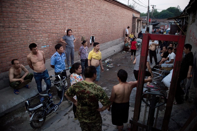 2017年，北京近郊一處農民工聚居的村落，警察試圖調解糾紛。（攝影／AFP／Nicolas ASFOURI）