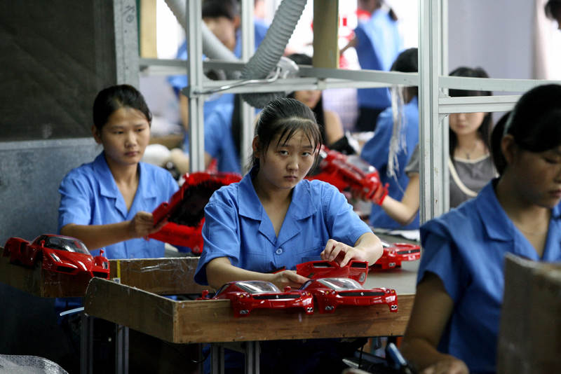 2007年，廣東省汕頭市一間玩具工廠內，女工正組裝玩具車。（攝影／AFP／Stephanie Wong）