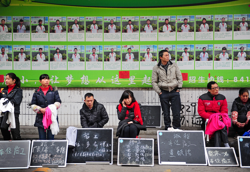 2014年，廣東省廣州市街頭，工廠工人的招募人員沿街排列。（攝影／Imaginechina via AFP／Qiao junwei）