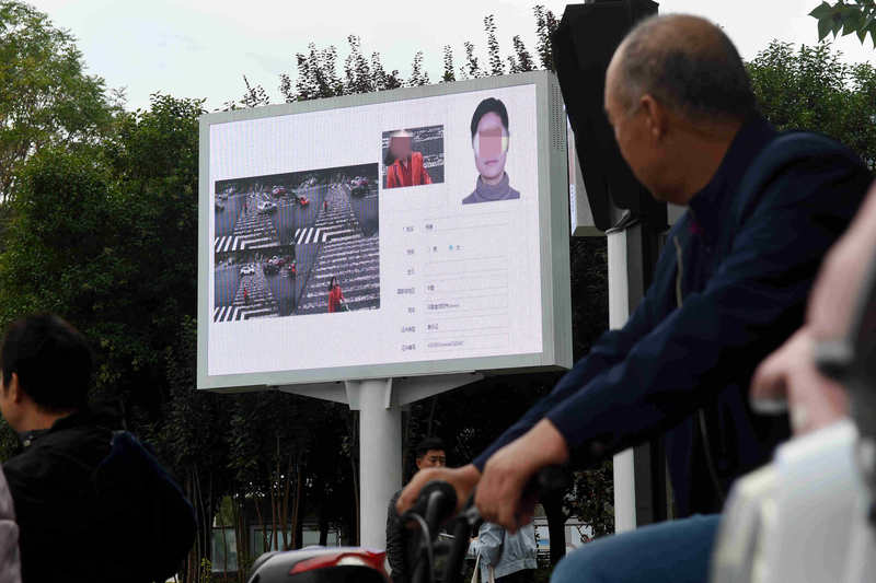 2019年，河南省洛陽市政府在街頭立起大型看板，顯示由監視系統及電腦面孔辨識的交通違規民眾資料。（攝影／Imaginechina via AFP／Zhang Yixi）