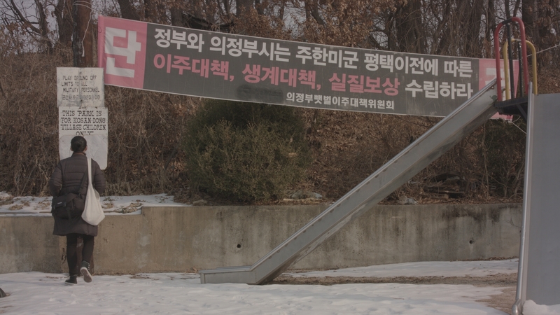 位在高山洞地區的罹原村是韓國目前少數僅存的基地村。此為「罹原村移居對策委員會」懸掛要求政府針對駐韓美軍基地遷出制定移居對策及賠償的標語。（劇照提供／TIDF）