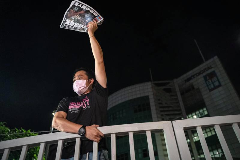 香港《蘋果日報》最後一夜，員工在大樓前發送剛出爐的最後一份報紙給前來致意的港人。（攝影／陳朗熹）