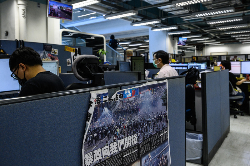 6月17日，香港警方大舉搜索並逮捕《蘋果日報》總編輯等5名主管後，報社職員在辦公室持續工作。（攝影／AFP／Anthony WALLACE）