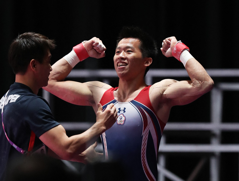 2018年8月23日，在雅加達舉行的亞洲運動會男子鞍馬項目比賽結果揭曉，得知自己獲勝的李智凱（右）振臂慶祝，教練林育信也上前祝賀。（攝影／The Yomiuri Shimbun via AFP／Koji Ito）