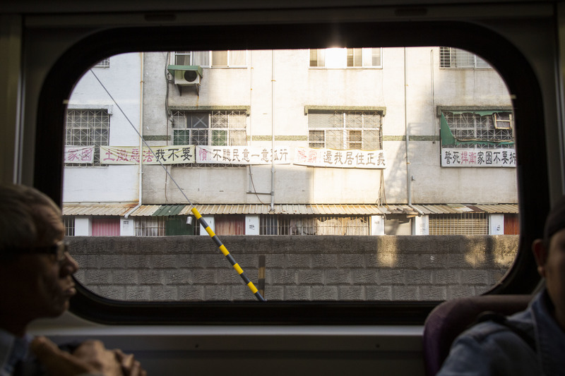 2019年4月6日，從一輛北上的區間車往外看，鐵路沿線住民懸掛的標語十分顯眼。（攝影／楊子磊）