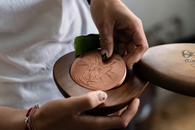 從小到大獲得無數獎牌獎狀的譚雅婷，自木匣中取出在2016年里約奧運奪得的射箭女團銅牌。（攝影／陳曉威）