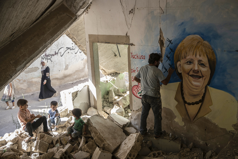 2021年9月27日，在敘利亞北部的城市，一位藝術家在受損的房屋內繪製了一幅梅克爾的壁畫，向她道別並表示感謝。（攝影／dpa Picture-Alliance via AFP／Anas Alkharboutli）