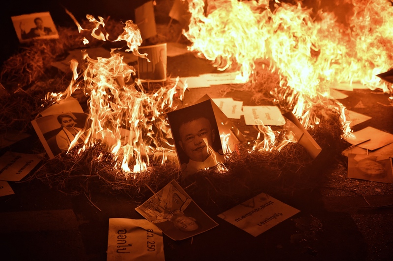 在曼谷的抗爭行動中，示威者焚燒泰國執政者與軍方代表的肖像表示抗議，要求泰國總理帕拉育（Prayut Chan-O-Cha）下台。（攝影／AFP／Lillian SUWANRUMPHA）