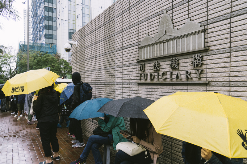 在西九龍裁判法院外，涉案家屬、朋友或支援者風雨不改的外輪候聽審。（攝影／陳朗熹）