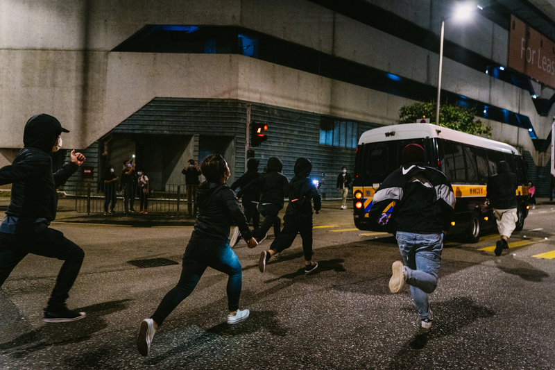支持者在香港西九龍法院外追送囚車。每當有示威或國安案件開審，警方都會在法院外封鎖道路，並截查追送囚車的人士。（攝影／陳朗熹）