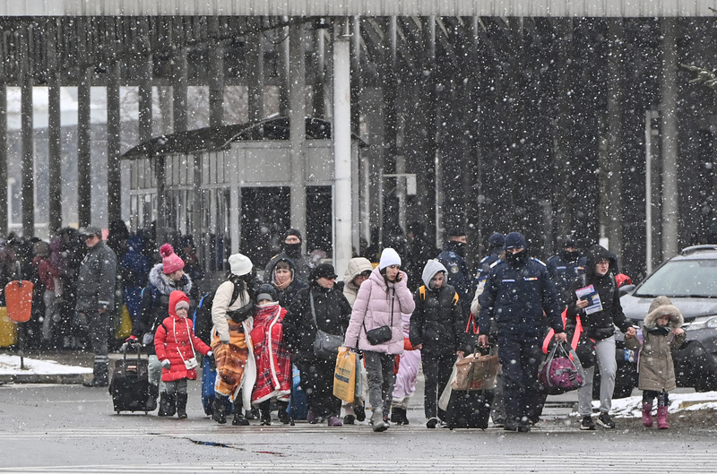 3月2日，躲避戰火的烏克蘭難民在雪天進入鄰近的羅馬尼亞邊境。（攝影／AFP／Daniel MIHAILESCU）