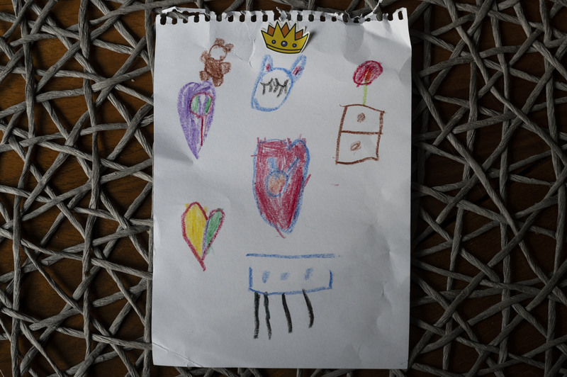 6歲的迪娜在離開羅曼紐克家前留下的圖畫，上頭有這個家中的貓、桌子和布偶。（攝影／楊子磊）