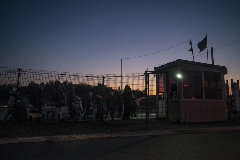 2022年3月13日傍晚，在烏克蘭與波蘭的邊境關口，一群帶著孩子的女性正要徒步通過國界，由於戰爭爆發後烏克蘭限制18至60歲的男性公民離境，因此逃亡的隊伍中多數都是母親與孩子。（攝影／楊子磊）