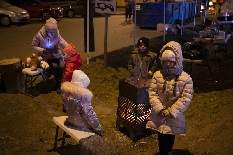 3月13日，在氣溫接近零度的深夜裡，一群剛抵達波蘭國境的烏克蘭孩子在公路旁烤火取暖。（攝影／楊子磊）