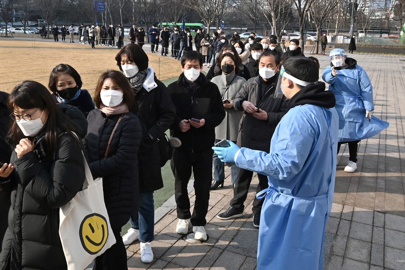 韓國Omicron疫情自年初逐漸升溫，3月中一度達到單日60萬人確診的高峰。圖為今年1月26日在首爾市政府外排隊準備接受篩檢的民眾。（攝影／AFP／Jung Yeon-je）