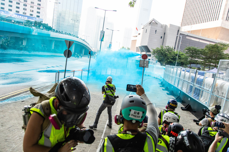 2019年10月1日，香港警察自政府總部的圍牆內向示威者和記者噴灑混有染色劑的高壓水柱。（攝影／SOPA Images／LightRocket via Getty Images／Willie Siau）