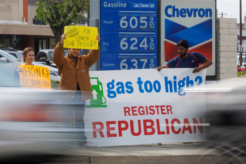 2022年3月29日，美國共和黨支持者在加州一處加油站外，手持訴求油價太高的標語，向準備加油的民眾爭取支持。（攝影／REUTERS／Mike Blake／達志影像）