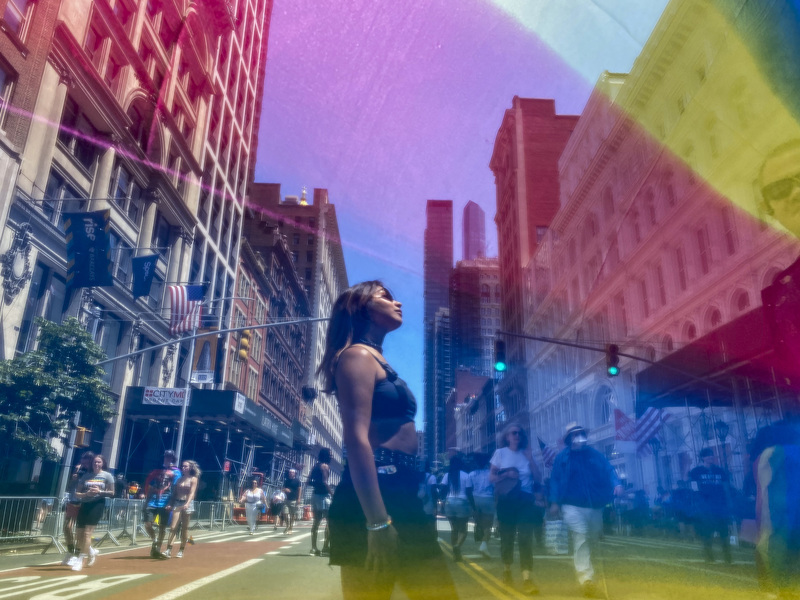 2022年6月26日，參與紐約同志遊行的民眾在麥迪遜廣場花園附近從一面彩虹旗前走過。（攝影／The Washington Post via Getty Images／Carolyn Van Houten）