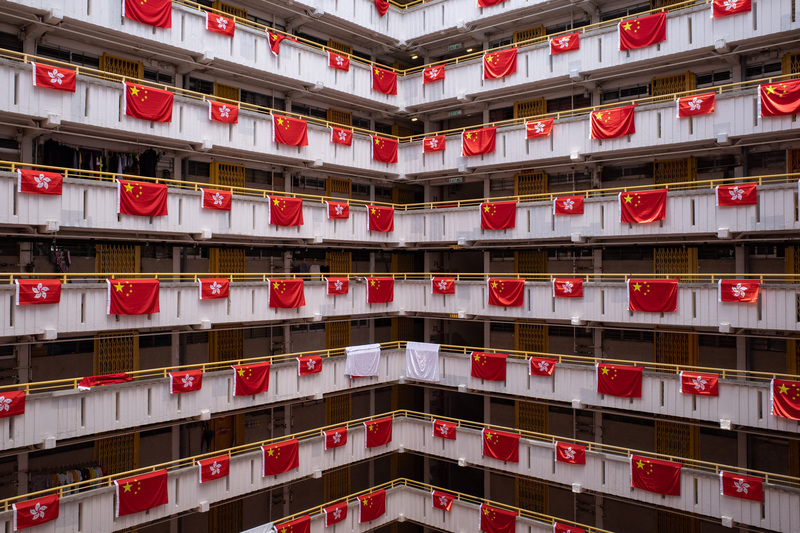 6月25日，為慶祝回歸25週年，香港一處公共住宅的各個樓層掛滿了特區區旗與中國國旗。除了引起輿論不同反應，也有旗幟被覆蓋或被剪斷掛繩。（攝影／Getty Images／Anthony Kwan）
