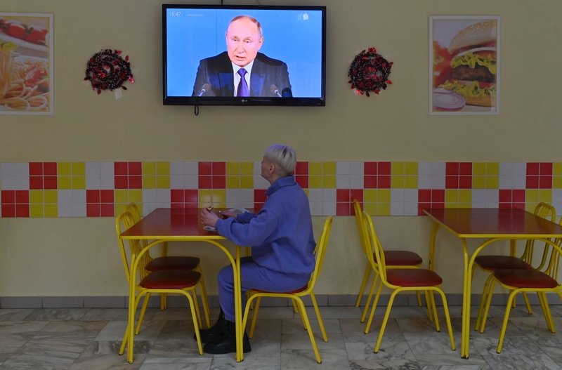 一名在鄂木斯克餐廳內民眾，觀看俄羅斯總統普丁在2021年終新聞談話新聞畫面。（攝影／Alexey Malgavko／Sputnik via AFP）