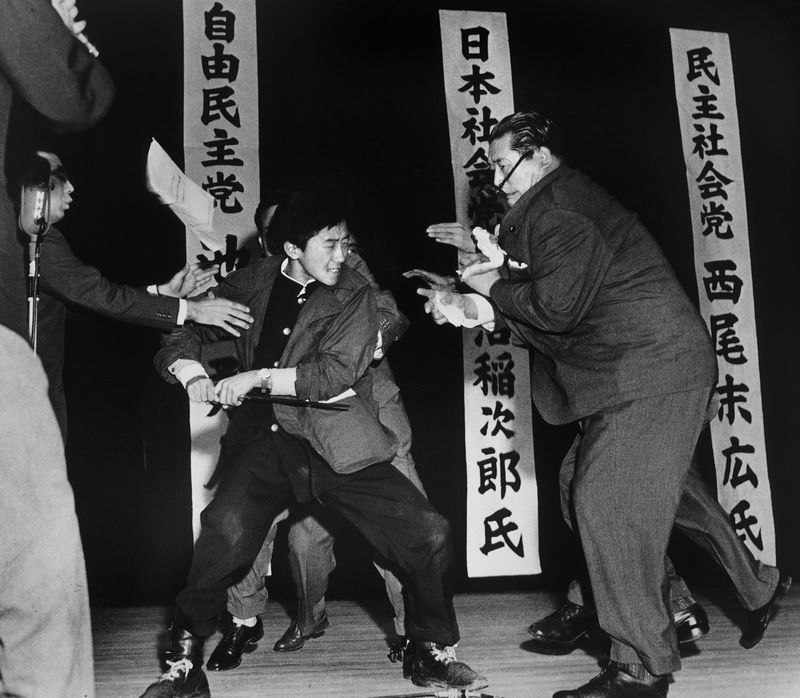 1960年10月12日，在東京日比谷公會堂舉行的三黨黨首選前演講會上，17歲的「大日本愛國黨」黨員山口二矢衝上演講台，以短刀刺殺社會黨委員長淺沼稻次郎。（攝影／Yasushi Nagao；影像來源／Worldpressphoto.org）