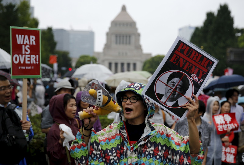 2015年8月30日，大批示威民眾在日本國會外，手持標語呼喊口號，抗議時任首相安倍晉三強行推動允許日本自衛隊部分行使集體自衛權的新安保法案。（攝影／REUTERS／Thomas Peter／達志影像）