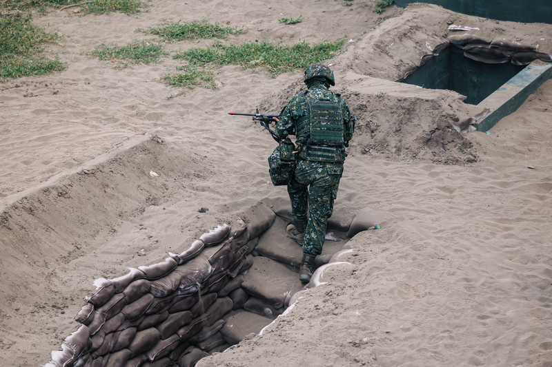 在新北八里地區執行「聯合反登陸作戰」操演中，自壕溝掩體中出擊的士兵。（攝影／鄭宇辰）