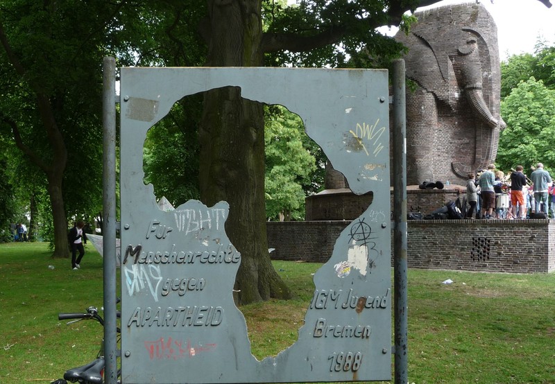 德國金屬工業工會青年部於1988年設立「支持人權，反對種族隔離」的紀念牌於〈帝國殖民榮譽紀念碑〉旁。（影像來源／Wikimedia Commons／Immanuel Giel）