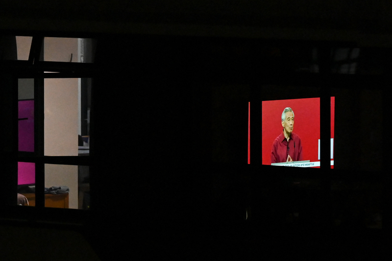 2022年8月21日，一間公寓住戶內的電視正在播放新加坡總理李顯龍在國慶群眾大會的現場轉播。（攝影／AFP／Roslan Rahman）