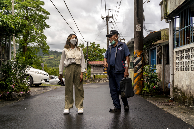 部落關係緊密，鄰里大概都知道哪家老人有失智狀況，寒溪樂智據點便逐村拜訪詢問。圖為拉比（Lapi Hayun，漢名羅雨涵）在新光部落與路上遇到的長者寒暄。（攝影／張家瑋）