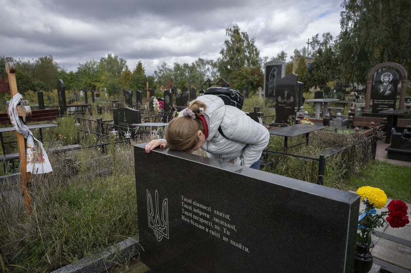 在布查城市日的悼念儀式後，一位居民獨自在有國徽的墓碑前哭泣。（攝影／楊子磊）