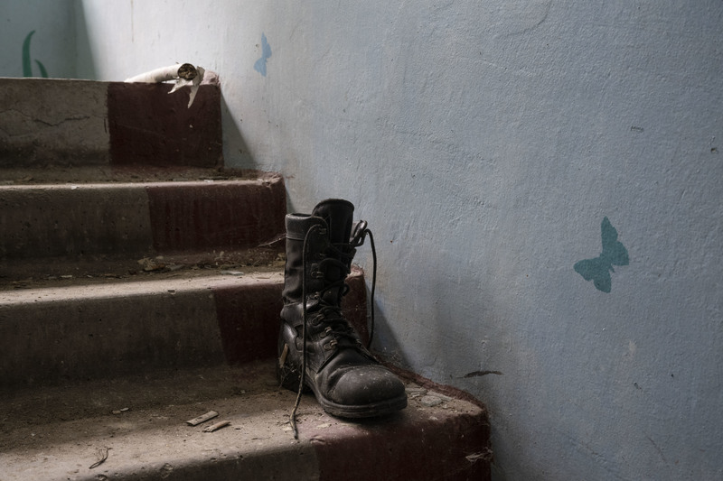 學校裡四處是入侵者留下的痕跡。許多俄軍拿走烏克蘭村民的鞋作為「戰利品」，撤軍時留下老舊過大的軍靴。（攝影／楊子磊）