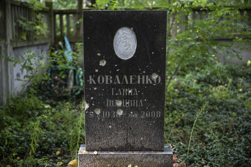 亞希德內的墓園裡，一些墓碑上仍有俄軍掃射過後留下的彈孔。（攝影／楊子磊）
