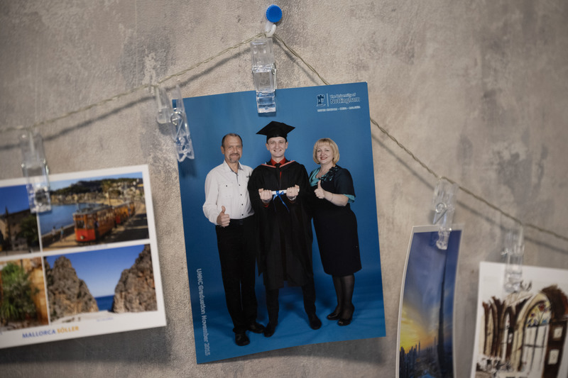 吉利在基輔的住處牆上，掛著畢業時與父母的合影。（攝影／楊子磊）