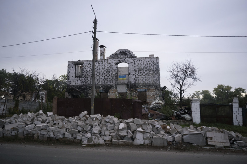 在基輔近郊的公路旁，一座被炸毀的房屋二樓掛著國旗。（攝影／楊子磊）
