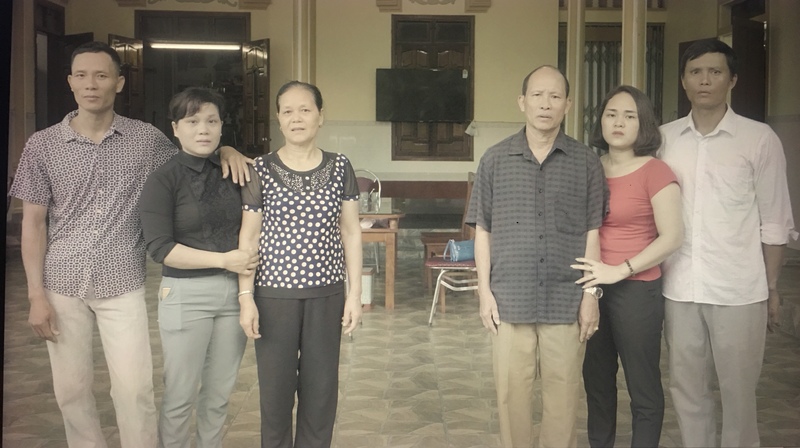 《九槍》劇組赴阮國非的老家越南中部義安省拍攝，為一家人留下失去重要成員後的全家福。圖中央兩位是阮國非的父母，左右兩側則是他的4位兄弟姊妹。（圖片來源／《九槍》提供）