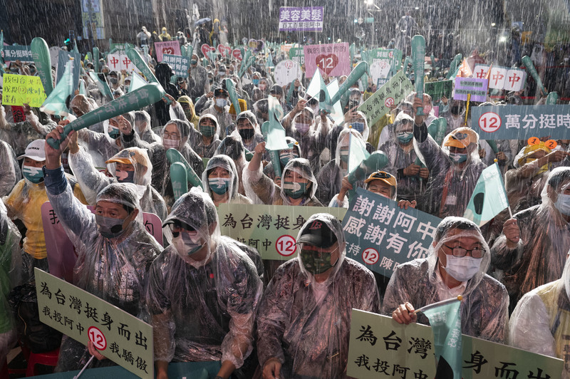 民進黨的支持群眾不畏雨勢，在選前一天參加候選人陳時中的造勢活動。（攝影／楊子磊）