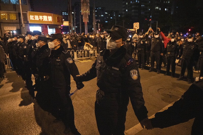 11月27日，北京市民拿白紙上街抗議，警方築起人牆擋住示威者。（攝影／AP Photo／Ng Han Guan）