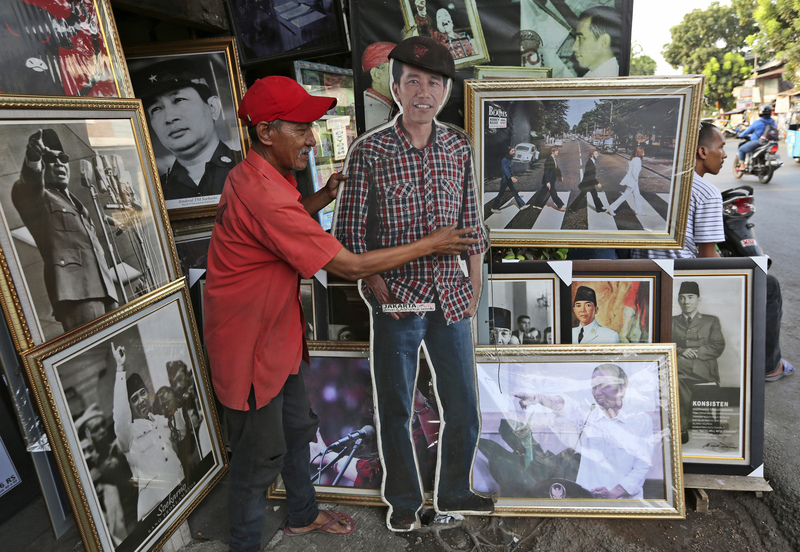 2019年9月20日，在雅加達的街頭，一名販售許多印尼領袖照片的街頭小販擺出佐科威的人形立牌。（攝影／AP Photo／Tatan Syuflana／達志影像）